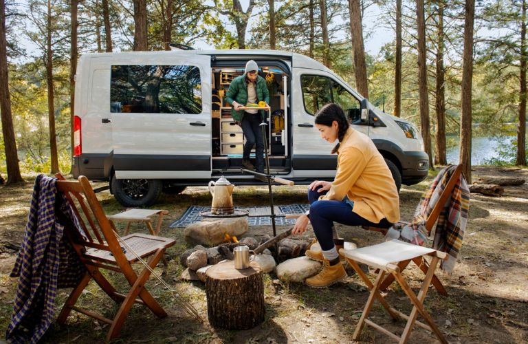 2023 Ford Transit Trail and Couple at a Campsite