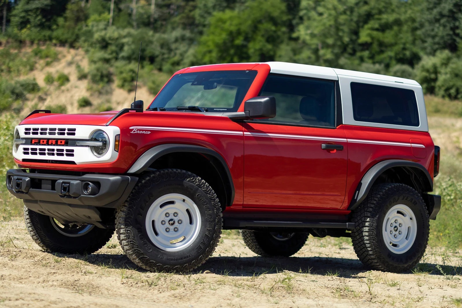 red Ford Bronco with white top off roading