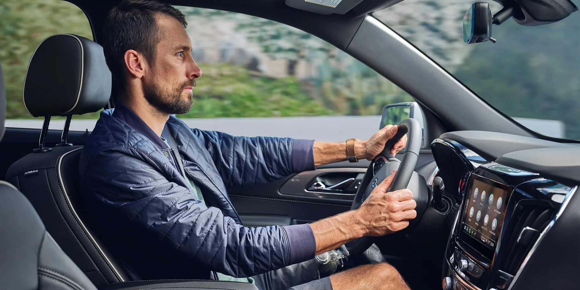 man driving in Chevrolet Traverse