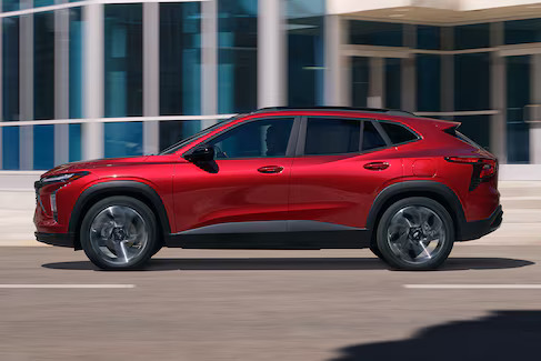 A red 2025 chevrolet Trax driving on a road.