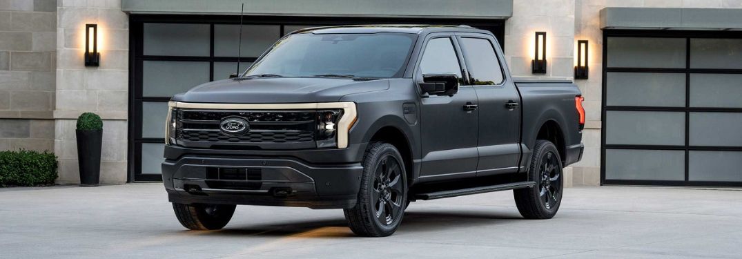 Black 2024 Ford F-150 Lightning Platinum Black Edition Front and Side Exterior in a Driveway