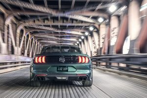 rear view of a green 2019 Ford Mustang Bullitt speeding through a tunnel