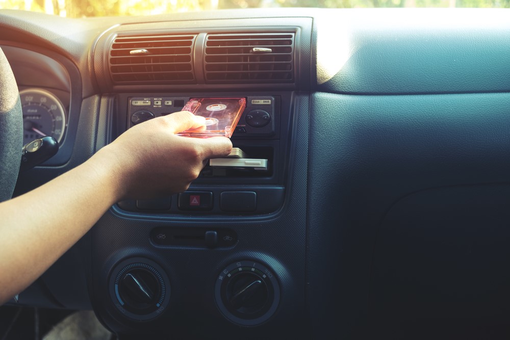 driver inserts cassette into their vehicle's cassette player