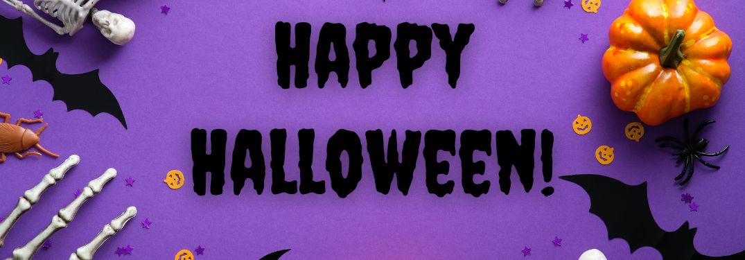 Purple Background with Halloween Decorations and Black Happy Halloween Text