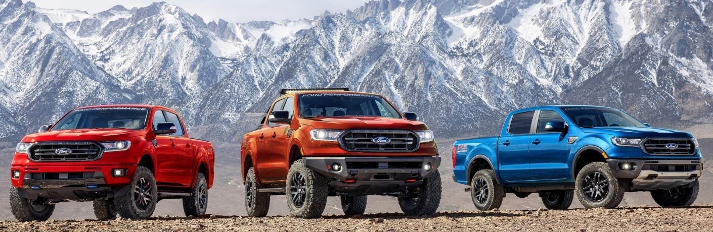 Red, Orange and Blue 2022 Ford Ranger Models in Front of Mountains