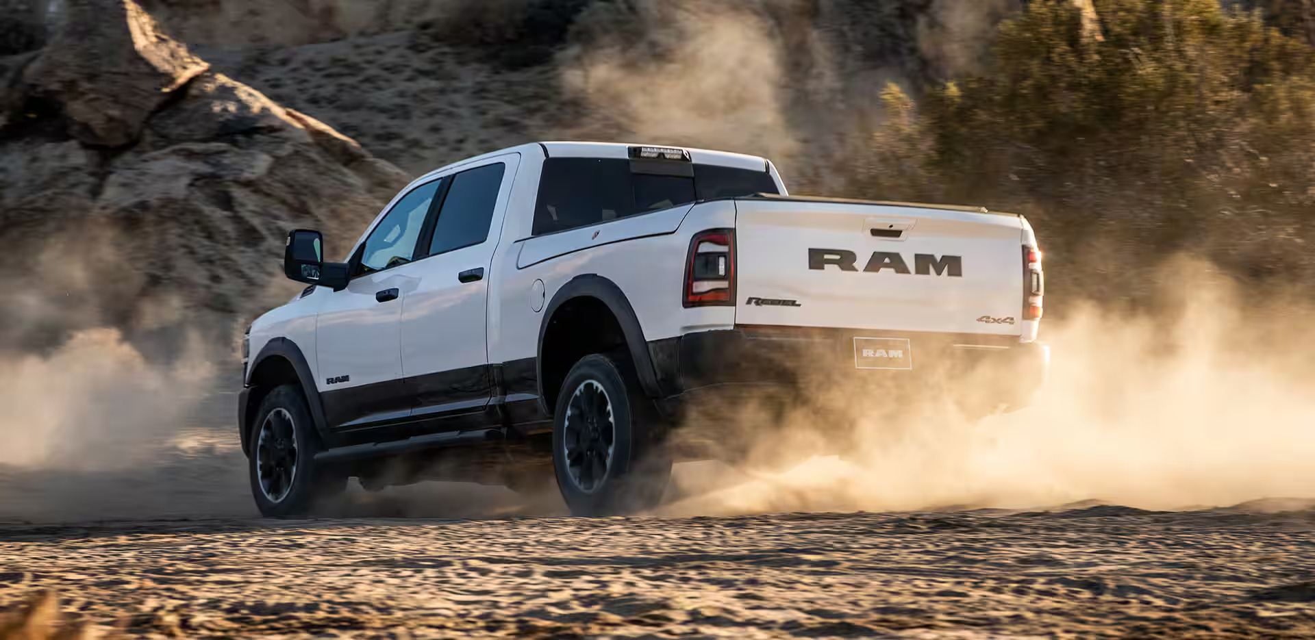 A white ram 2500 drivong throug the sand.