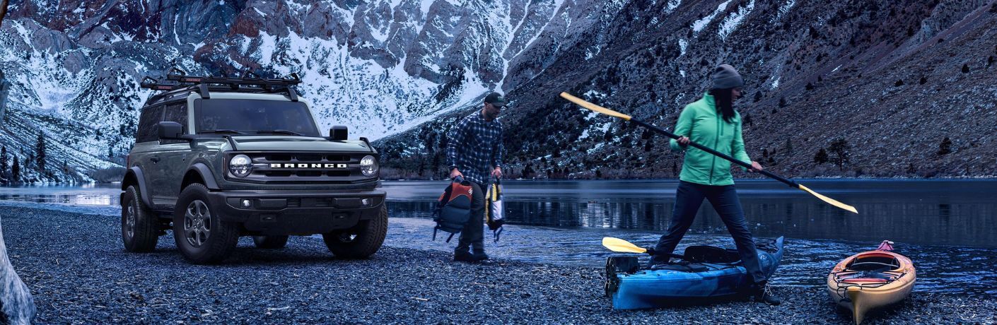 Gray 2023 Ford Bronco and Couple Next to Lake with Kayaks