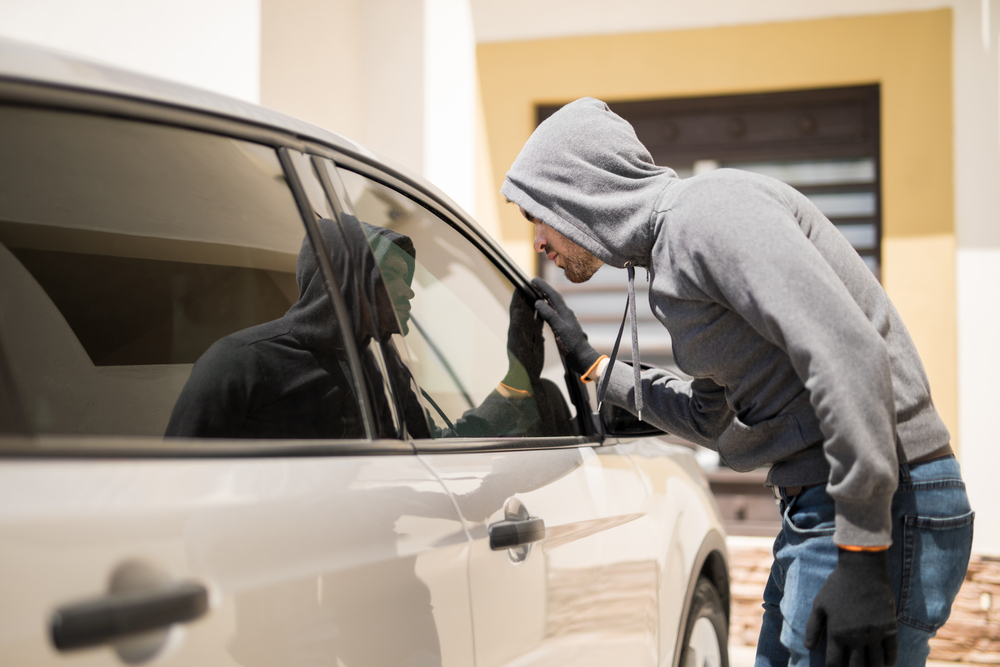 hooded man peers into car