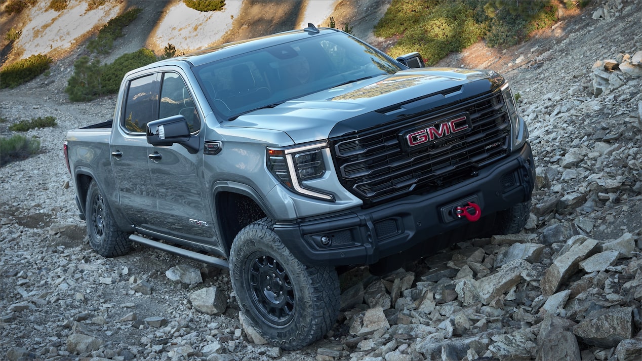 Front view of gray 2023 GMC Sierra AT4X climbing up rocks
