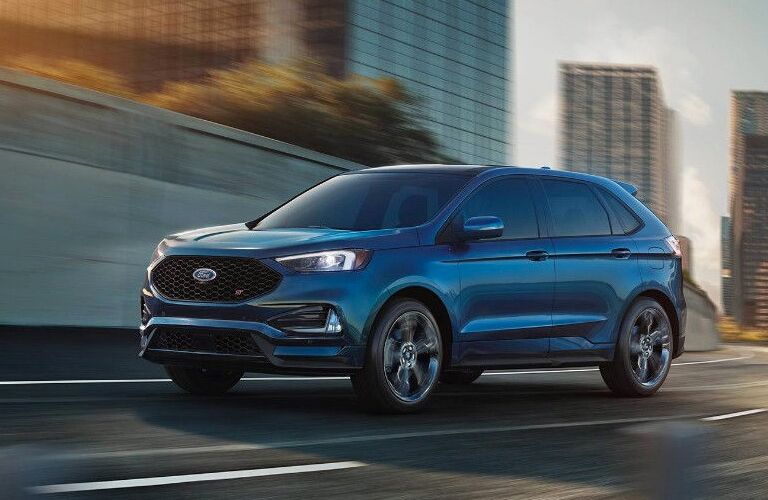 side view of a blue 2019 Ford Edge ST driving on a highway