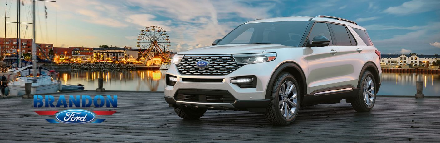 White 2020 Ford Explorer Next to Water and City Lights with Brandon Ford Logo