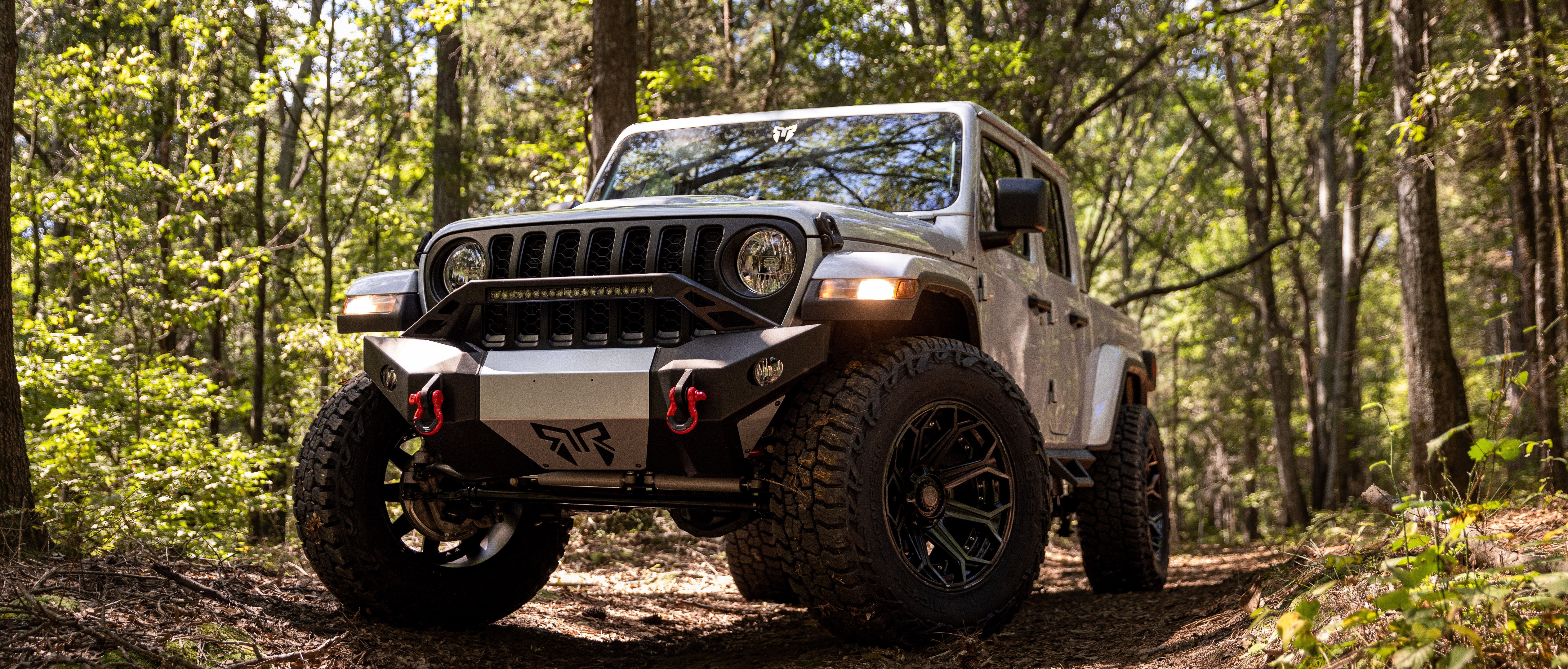 white jeep gladiator with Rocky Ridge upfit, in the woods