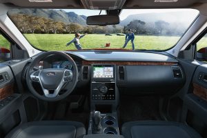 2018 Ford Flex driver dash and infotainment system with father and son seen playing through windshield