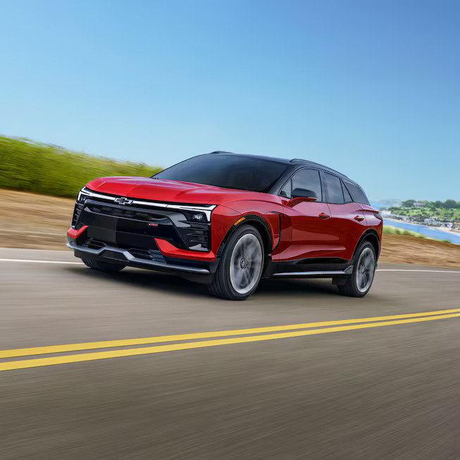 A red chevy blazer ev friving on a road.