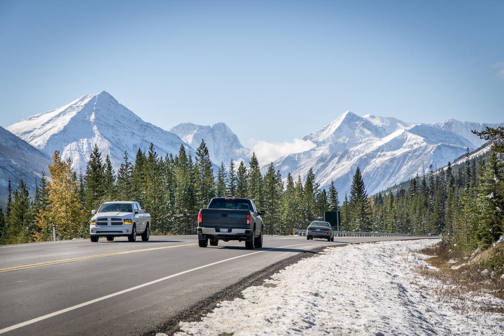 two trucks passing on a road in the mountains