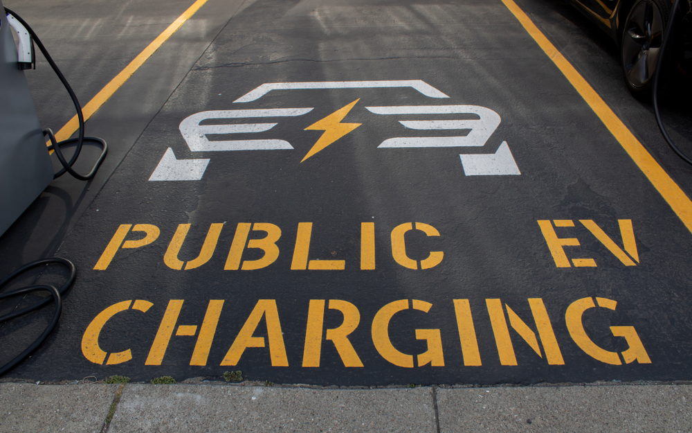 electric vehicle charging station parking spot in a parking lot that reads: Public EV Charging