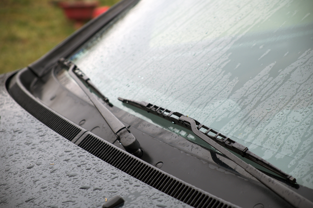 Close-up of windshield wipers on a wet windshield.