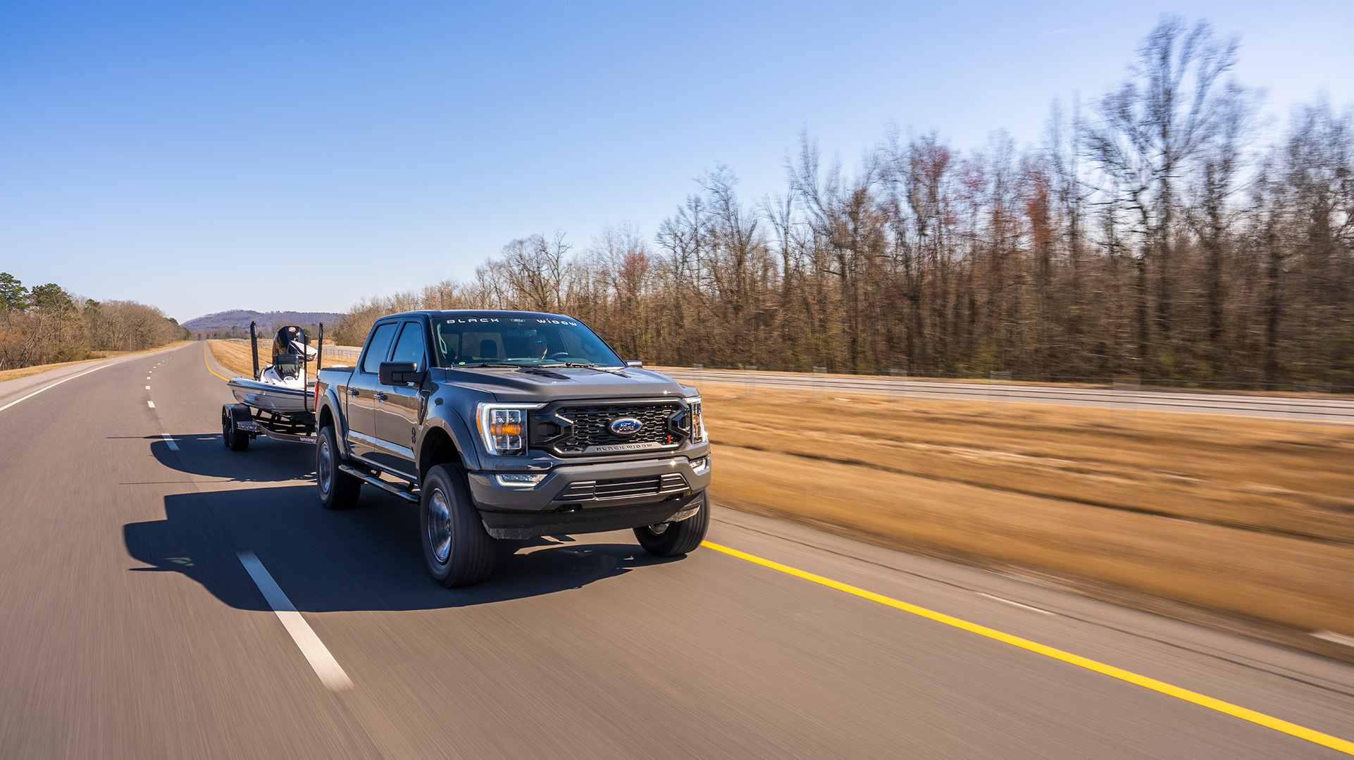 a gray 2021 Ford F-150 Black Widow towing a boat