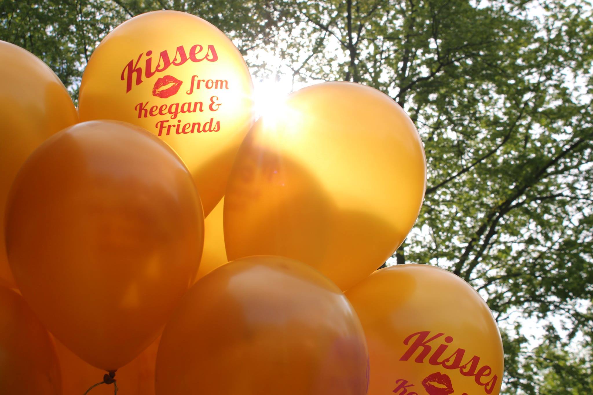 yellow balloons that say "Kisses From Keegan & Friends" in red font