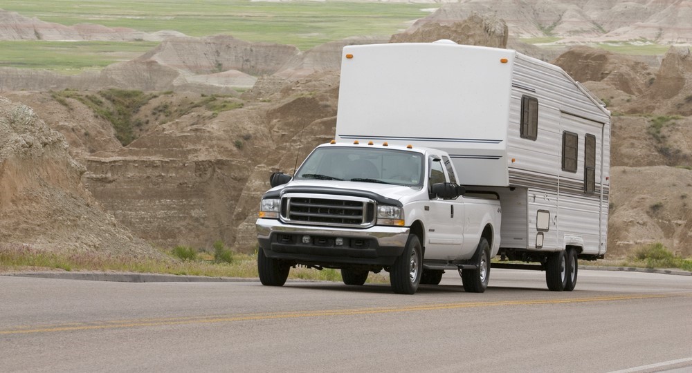 white truck towing a white RV