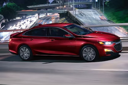 a red car driving on a bridge