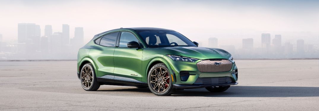 Green 2024 Ford Mustang Mach-E GT with Bronze Appearance Package in Front of City Skyline