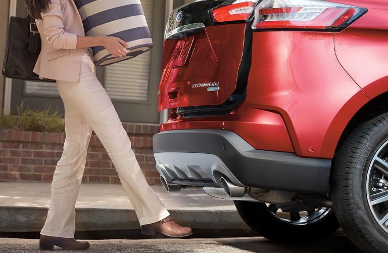 woman using foot activated tailgate of a red 2021 Ford Edge ST-Line