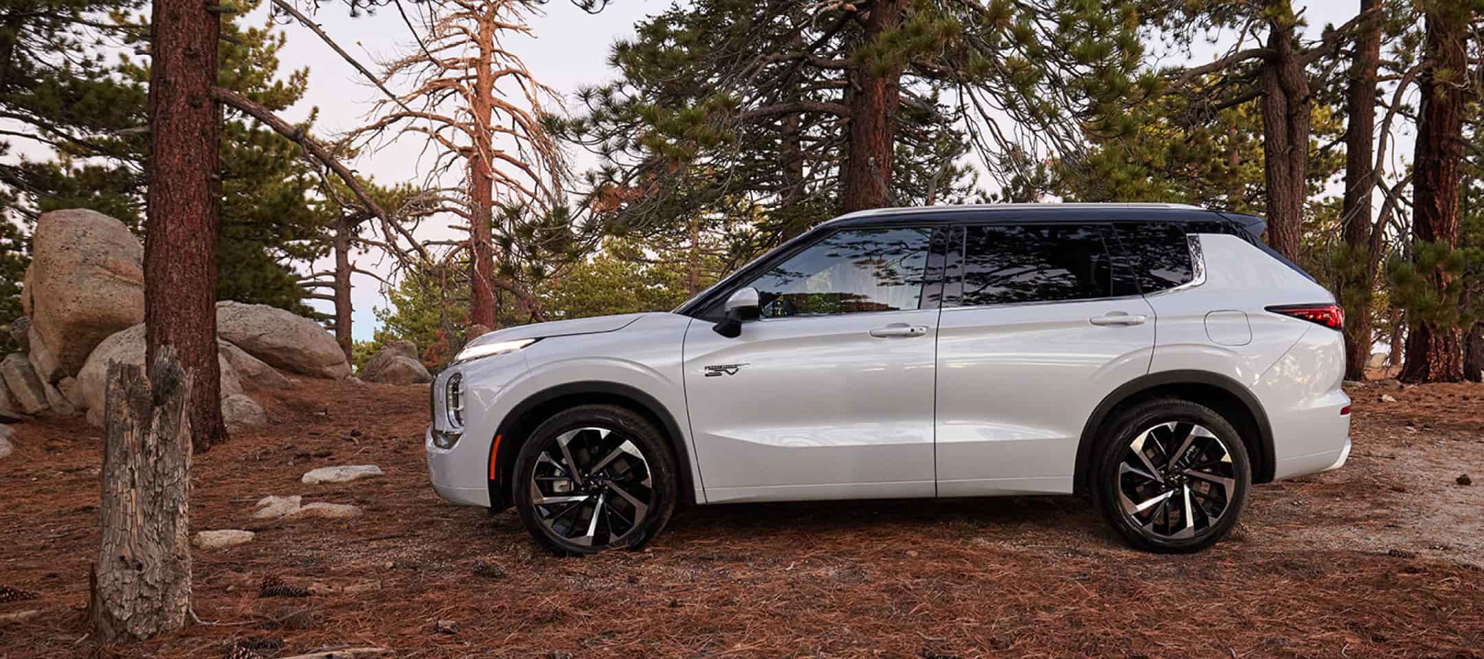 white 2024 Mitsubishi Outlander parked in a forest