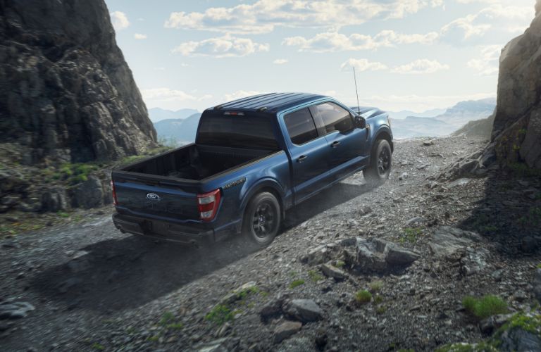 Blue 2023 Ford F-150 Rattler Rear Exterior on a Dirt Trail