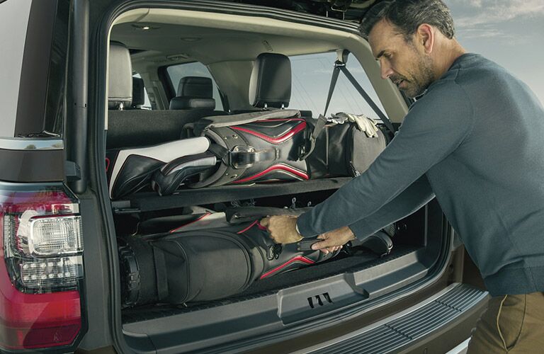 man loading up rear cargo area of his 2021 Ford Expedition MAX