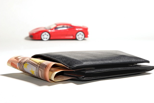 Red Toy Car in background, wallet with cash in it in foreground