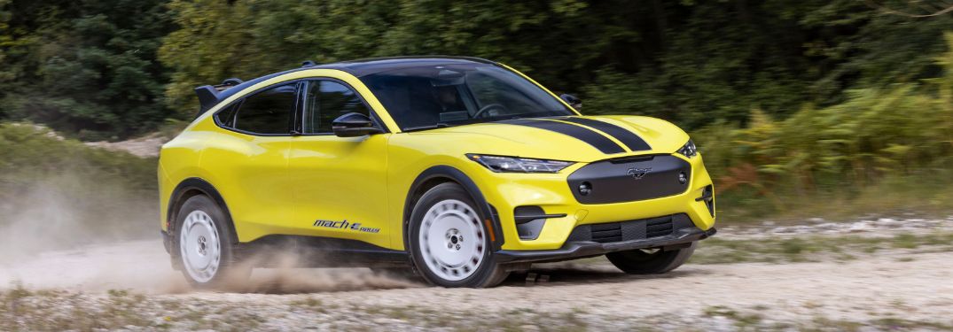 Yellow 2024 Ford Mustang Mach-E Rally with Black Stripes on Dirt Road