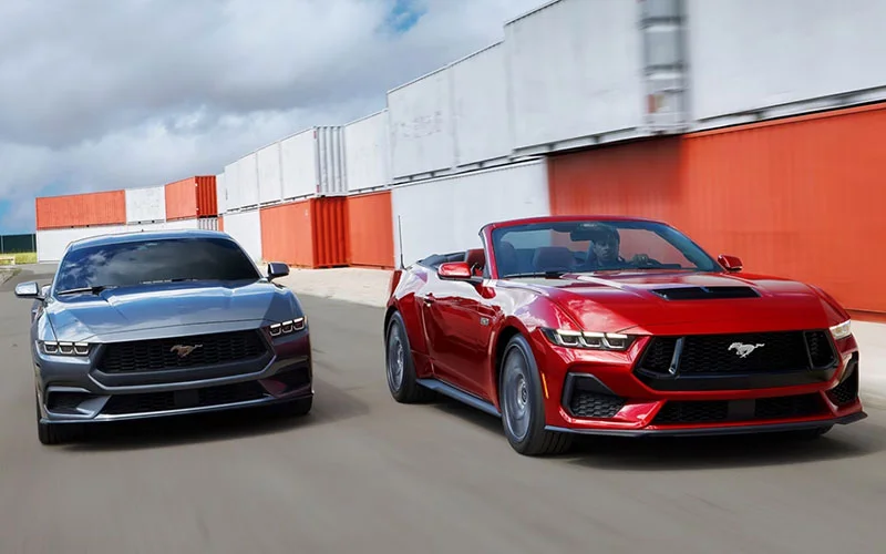 image of red and grey mustang driving parallel to each other