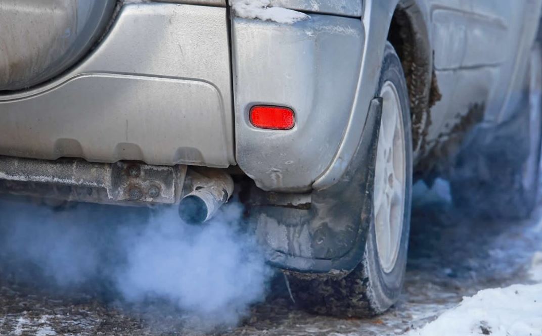 silver vehicle sitting idle in winter while exhaust comes out of the tailpipe