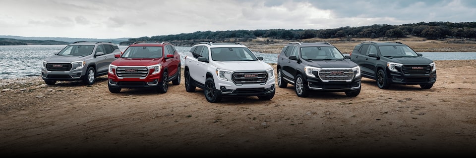 a group of suvs parked on a beach near the water