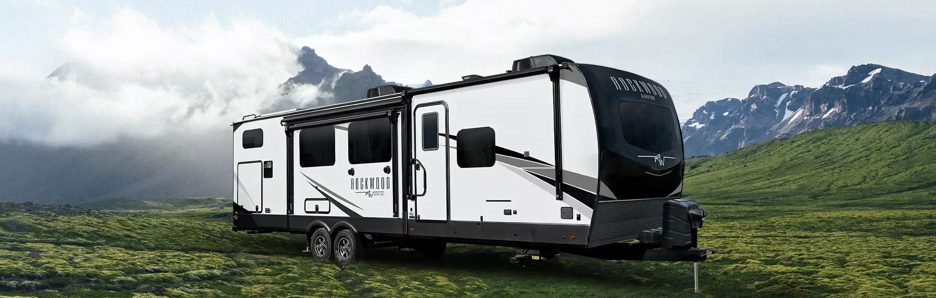 Forest River Rockwood Signature Travel Trailer parked in front of a mountainous background