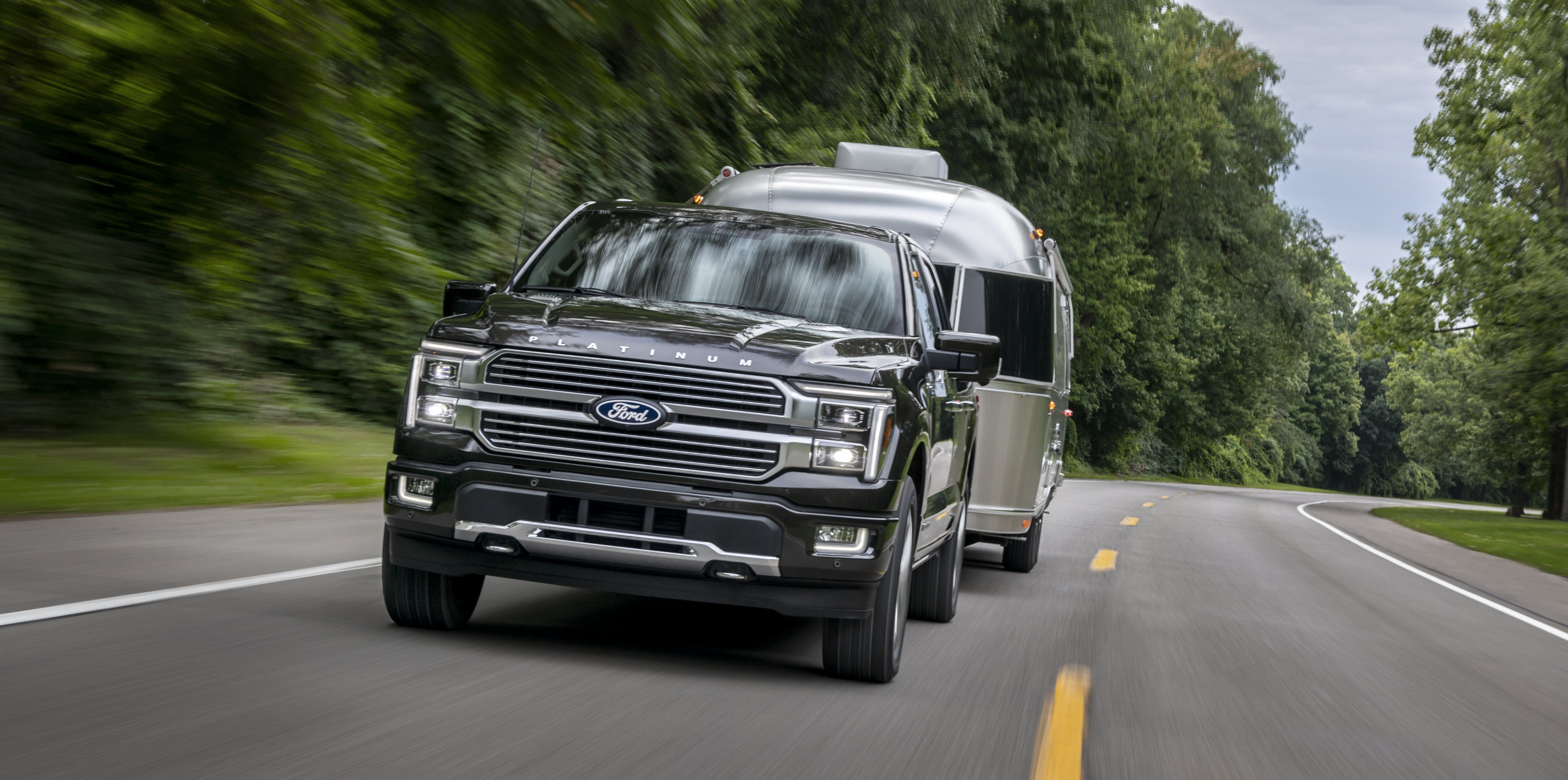 2024 Ford F-150 towing a trailer on a forest road
