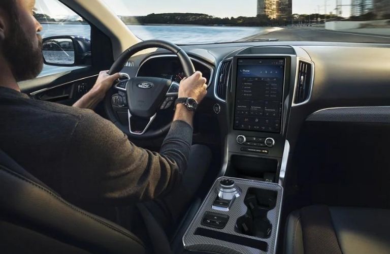 A person driving the 2022 Ford Edge near a beach.