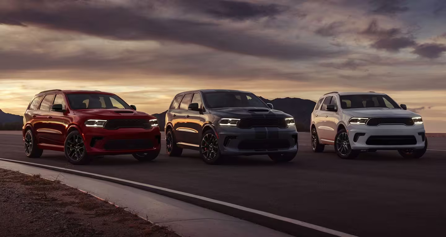 3 suvs parked on a road 