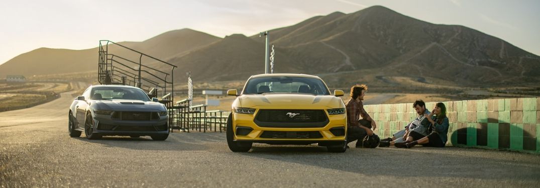 Blue and Yellow 2024 Ford Mustang Models at the Track at Sunset