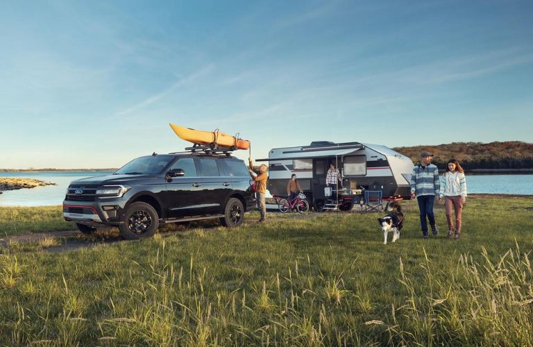 Black 2024 Ford Expedition with Camper Trailer and Family by Water