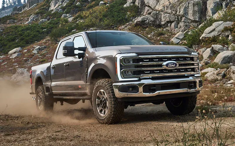 image of black ford truck driving on dirt road