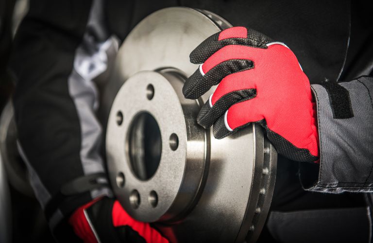 Mechanic with Red Gloves Holding Brake Rotor