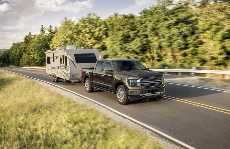 Gray 2024 Ford F-150 on a Highway Towing a Camper