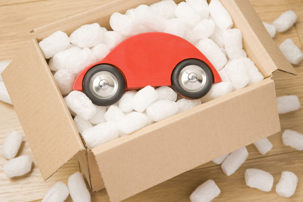 red toy car set on top of packing peanuts inside of an open cardboard box