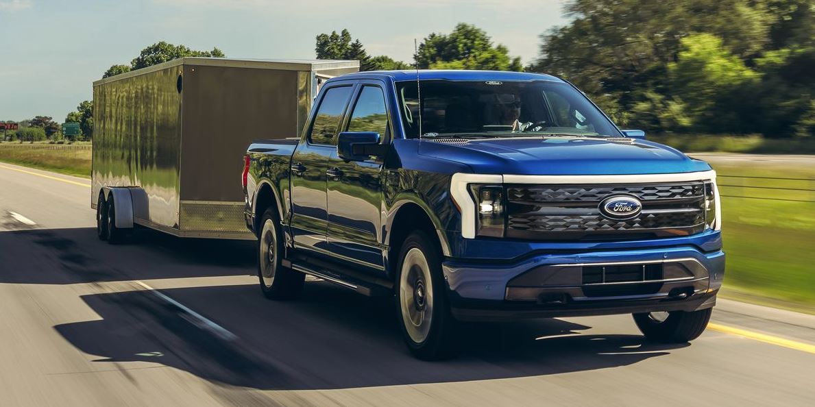 Blue 2023 Ford Lightning towing a trailer