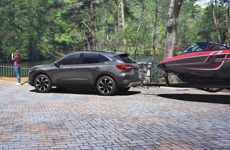 Rear Exterior of a Gray 2025 Ford Escape Towing a Boat by Water