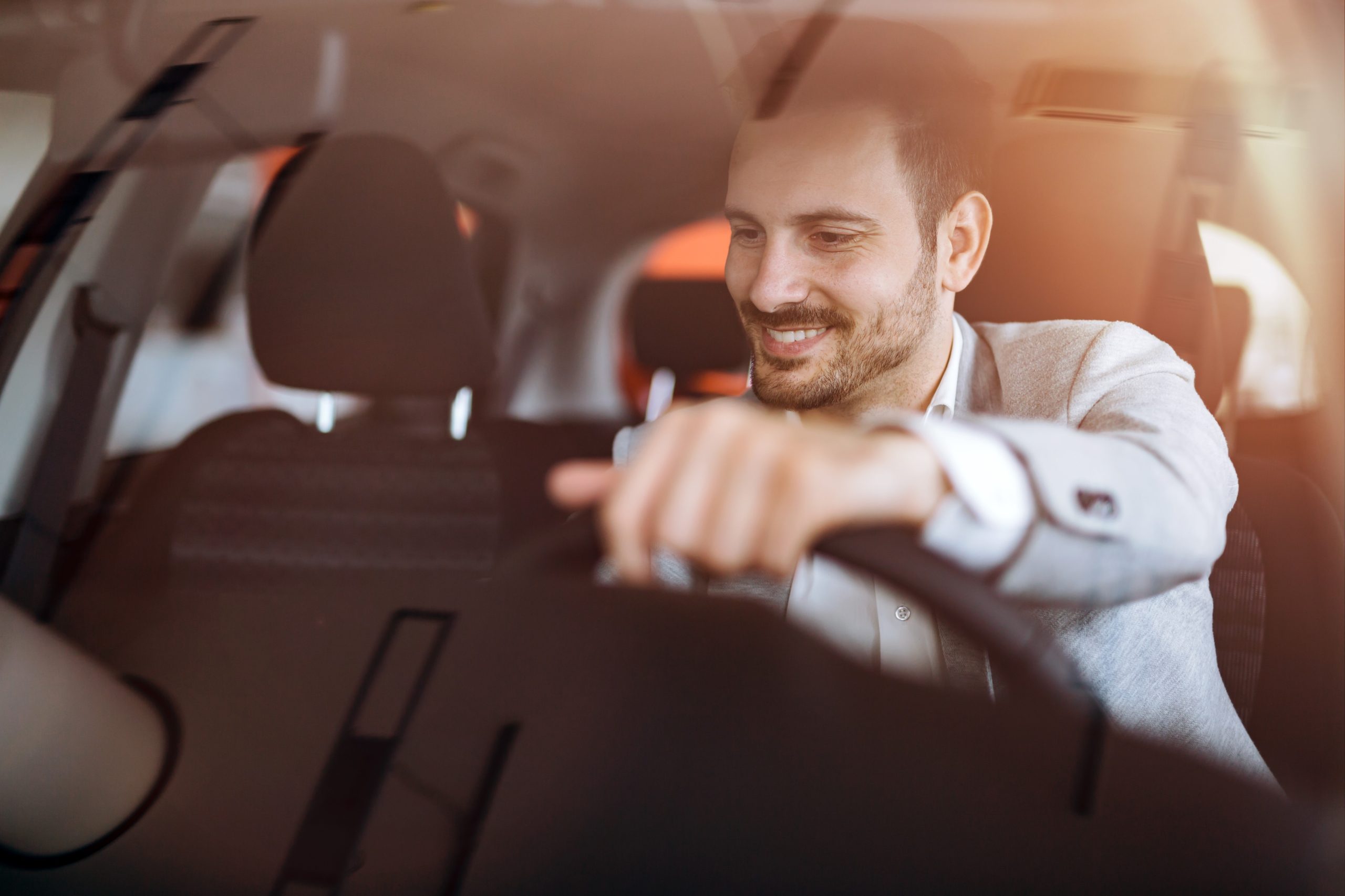 man smiling at radio in car