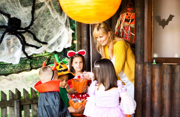 Mom Putting Candy in Trick or Treaters Buckets