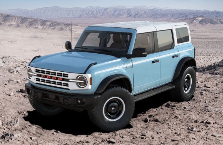 Blue 2024 Ford Bronco with White Roof Panel in a Desert